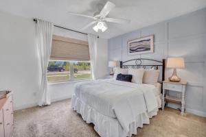 a bedroom with a bed with a ceiling fan and a window at Anchors Away in Panama City