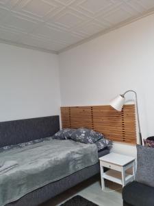 een slaapkamer met een bed, een lamp en een stoel bij Kompakti yksiö pienkerrostalossa in Pori