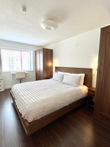 een slaapkamer met een groot bed en een houten vloer bij Quiet, Luxury Apt in Dublin. in Dublin