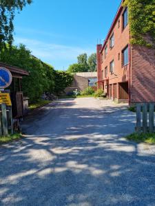 an empty street next to a brick building at Kompakti yksiö pienkerrostalossa in Pori