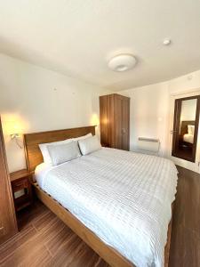 a bedroom with a large bed with white sheets at Quiet, Luxury Apt in Dublin. in Dublin