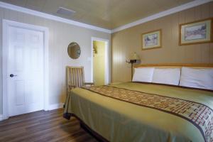 a bedroom with a large bed and a white door at Green Gables Motel & Suites in Burney