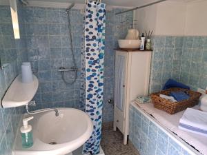 a blue tiled bathroom with a sink and a shower at Sommersitz in Hohnstorf