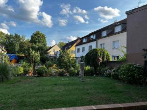 a yard with a house and a garden with flowers at Modernes Apartment in Stadionnähe in Gelsenkirchen
