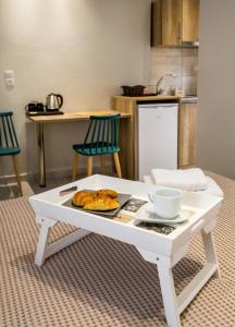 a white coffee table with a plate of food on it at Le Vieux Quartier in Limenaria