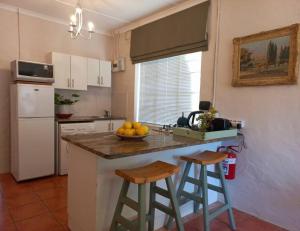 a kitchen with a counter with a bowl of fruit on it at Cozy Garden Cottage! in Grahamstown