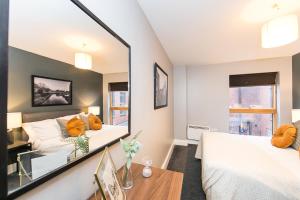 una camera da letto con specchio, letto e tavolo di Ancoats House a Manchester