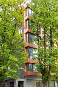 a tall building with windows in the middle of trees at Around the globe apartment in Varna City
