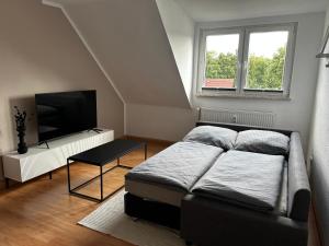 a bedroom with a bed and a flat screen tv at Modernes Apartment in Stadionnähe in Gelsenkirchen