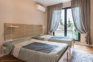 a bedroom with two beds and a large window at Around the globe apartment in Varna City