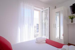 a white room with a bed and a large window at Guest House Milan in Hvar