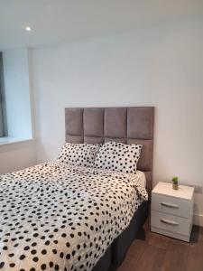 1 dormitorio con 1 cama con edredón blanco y negro en 2BR Chic London Sleep 9 BP7, en Londres