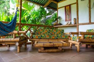 una veranda con sedie e amache su una casa di CABAÑA FAMILIAR en EcoparqueChinauta, PISCINA, GRANJA, JUEGOS, PESCA, RESTAURANTE a Fusagasugá