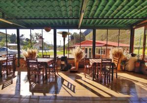 a patio with tables and chairs and a green roof at HOTEL MIL ESTRELLAS-TOROTORo in Torotoro