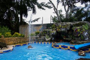 uma piscina com um escorrega aquático num parque em CABAÑA FAMILIAR en EcoparqueChinauta, PISCINA, GRANJA, JUEGOS, PESCA, RESTAURANTE em Fusagasugá