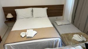 Una habitación de hotel con dos camas con guantes puestos. en Flat Espetacular em Porto de Galinhas Mana Beach Experiênce, en Porto de Galinhas