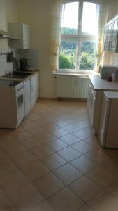 a kitchen with white appliances and a large window at Ferienwohnung Sonnenblick in Burkhardtsdorf