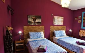 1 dormitorio con 2 camas y paredes moradas en Bed & Breakfast Alegria y Luna, en Sorbas