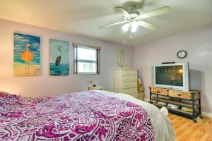 a bedroom with a bed and a tv and a ceiling fan at Sunny Florida Escape - Patio and Grill, Near Beaches in St Pete Beach