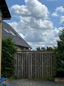 een houten hek voor een huis bij 120 kvm lejlighed med have i kælderniveau in Tølløse