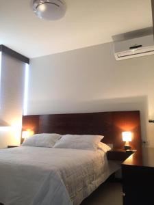 a bedroom with a large bed with two night stands and two lamps at Apartamento amplio y moderno en el centro de Santa Cruz, con PARQUEO e Internet, cerca de EQUIPETROL in Santa Cruz de la Sierra