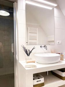 a white bathroom with a sink and a mirror at Beach & Castle - Sines Apartment in Sines