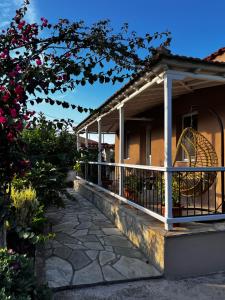 un porche de una casa con una valla y flores en Skapin house, en Skopelos Town