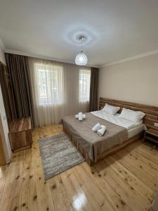 a bedroom with a large bed with towels on it at Polaris Kazbegi in Stepantsminda