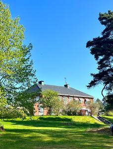 un gran edificio de ladrillo en un césped verde en Villa Billerud, en Säffle