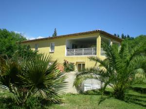 een geel huis met een balkon en palmbomen bij shargib2 - 70m2 au rdc d une jolie villa in Saint-Paul-de-Vence