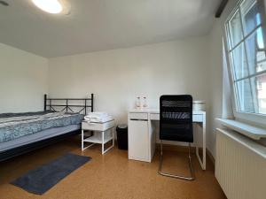 a bedroom with a bed and a desk and a chair at Mehrere Zimmer in erster Lage in Siegen