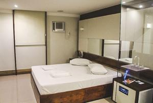 um quarto com uma cama grande e um espelho em HOTEL PORTELÃO no Rio de Janeiro
