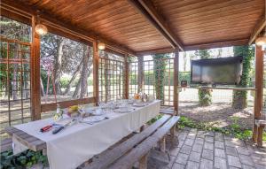 uma mesa de jantar num pavilhão com uma televisão em Beautiful Home In Rivotorto Di Assisi With Wifi em Passaggio Di Assisi
