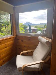 a living room with a chair and a window at Cabin in Trawsfynydd