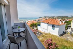 a balcony with a table and chairs and a view at Le Vieux Quartier in Limenaria