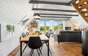 a dining room and living room with a table and chairs at Nice Home In Hvide Sande With Sauna in Bjerregård