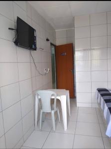 a white table and chair in a room with a tv at HOTEL CIDADE EXPRESS 24H in Teresina