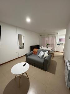a living room with a couch and a table at Apartamento a metros de la costanera y el lago in Villa María
