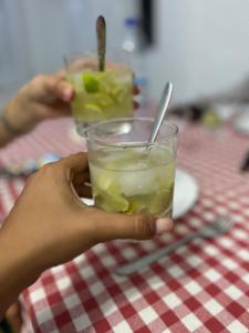 una persona che tiene un bicchiere di limonata su un tavolo di Ô Bercail du Sud chez Jeannette a Rodrigues Island