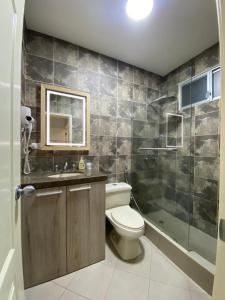 a bathroom with a toilet and a sink and a shower at Cozy & Chic Apartment in beautiful area in Guayaquil