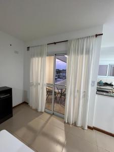 a living room with a sliding glass door with a balcony at Apartamento a metros de la costanera y el lago in Villa María