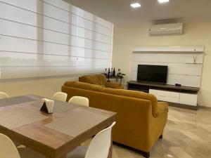a living room with a couch and a table and a tv at Cozy & Chic Apartment in beautiful area in Guayaquil
