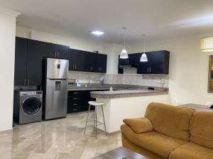 a kitchen with black cabinets and a stainless steel refrigerator at Cozy & Chic Apartment in beautiful area in Guayaquil