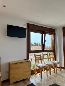 a living room with two chairs and a flat screen tv at Top Sanxenxo Resort in Sanxenxo