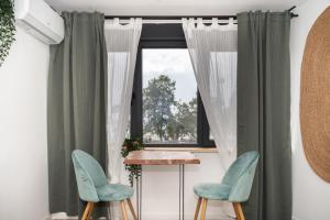 アリカンテにあるEl Miradorの椅子2脚と窓が備わる客室です。