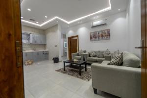 a living room with couches and a table and a kitchen at Taif promise Chalets in Taif