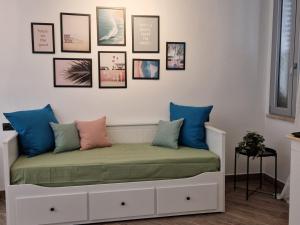 een bed met kussens en foto's aan de muur bij Suite Da Gabry 2 in Olbia