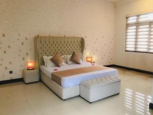 a bedroom with a large bed with two lamps at Royal Retreat Kandy in Kandy