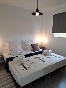 two beds in a room with white walls at Les Villas Jalnas logement HATEYA in Les Trois-Îlets