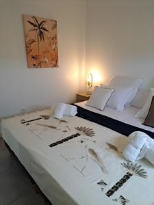 a bedroom with two beds with white sheets and a painting at Les Villas Jalnas logement HATEYA in Les Trois-Îlets